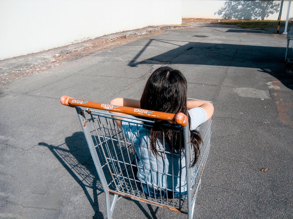 Muchacha en el carrito de la compra gris