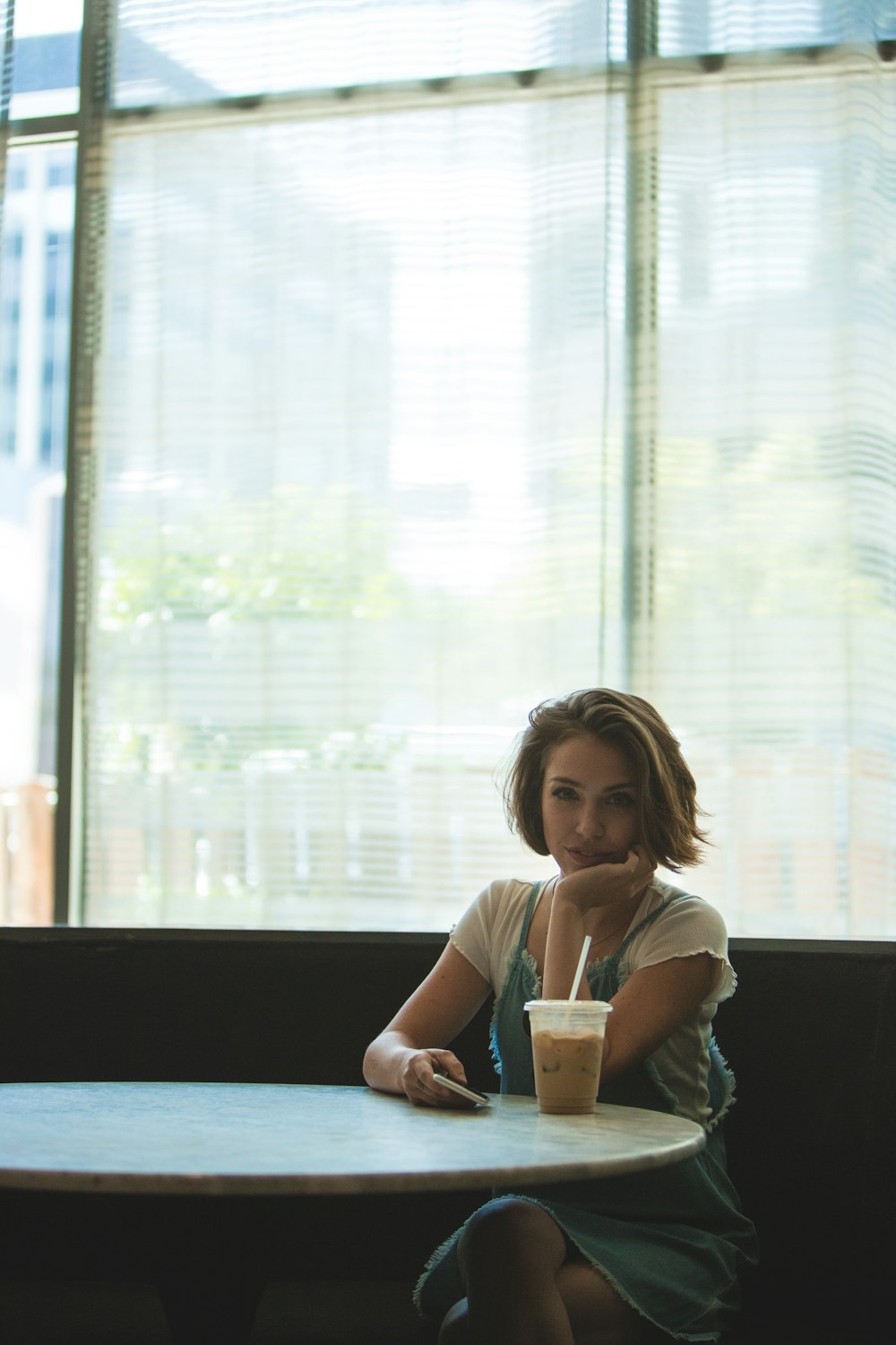 woman sitting facing chair with hands on chin