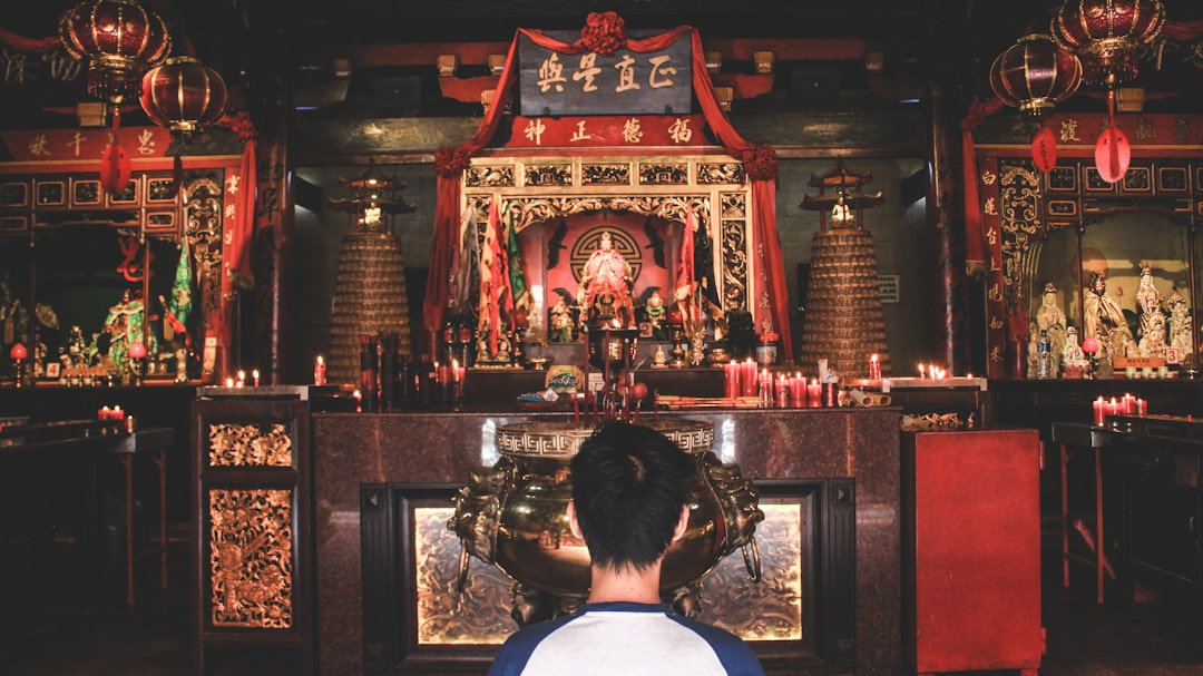 person wearing blue and white top watching statuettes in the room