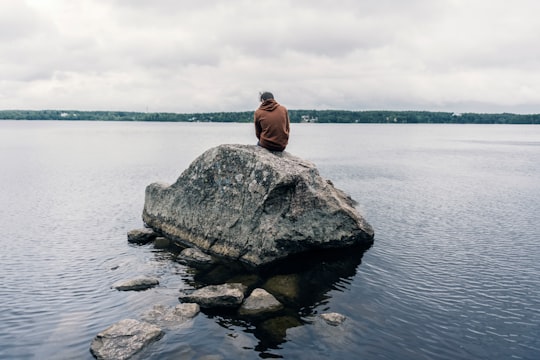 person sitting on rock surrounded by water in Saint Petersburg Russia