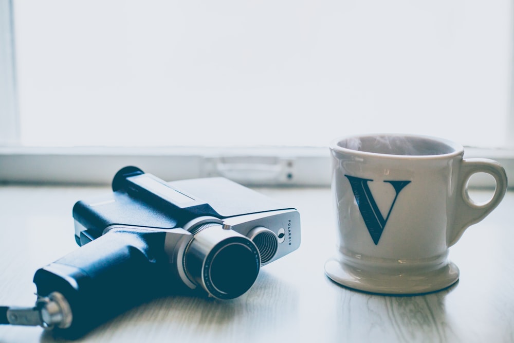 white and green ceramic mug on table