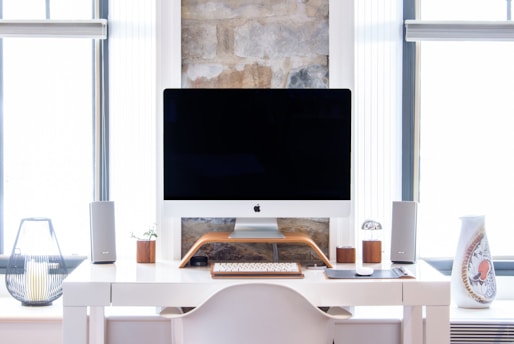 white iMac on top white desk