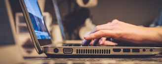 person using silver laptop computer on desk