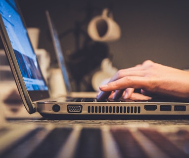 person using silver laptop computer on desk