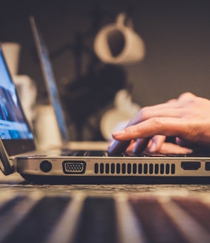 person using silver laptop computer on desk