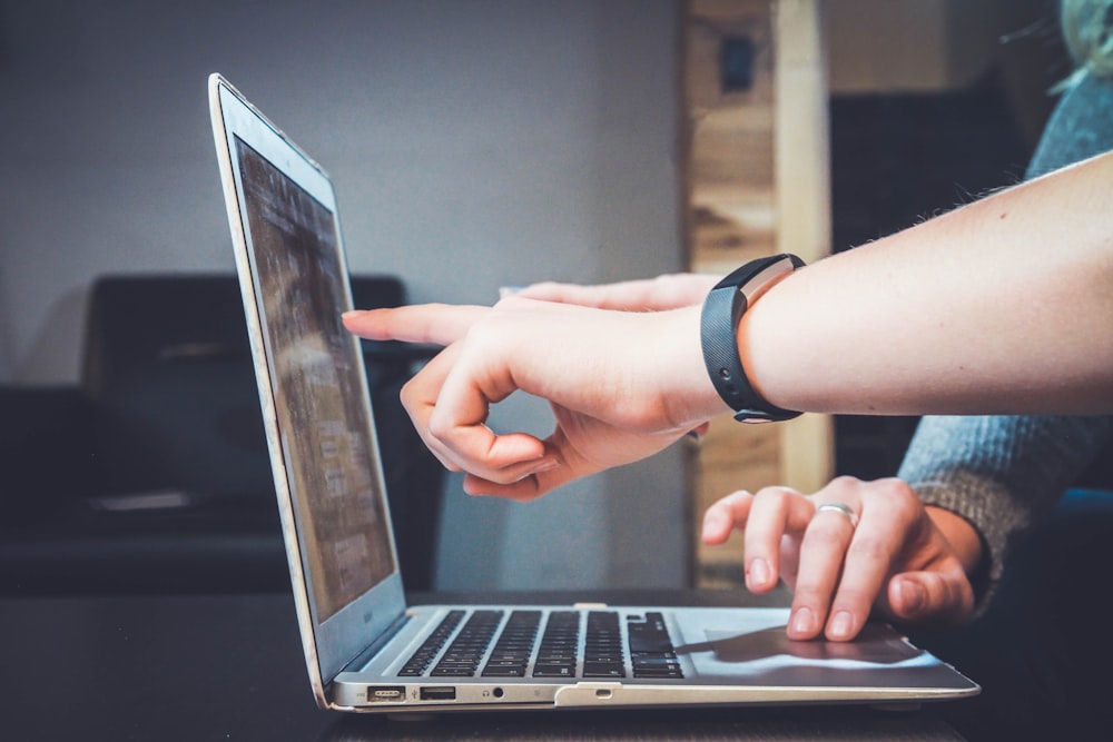 Two people looking at the laptop, researching together.