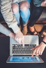 three person pointing the silver laptop computer