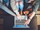 three person pointing the silver laptop computer