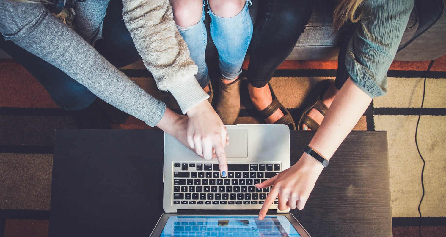 three person pointing the silver laptop computer