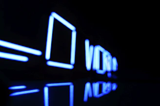 A glowing neon-blue abstract tech illustration with floating micro-shapes on a dark background.