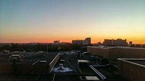 Technician servicing an HVAC unit on a sunny rooftop