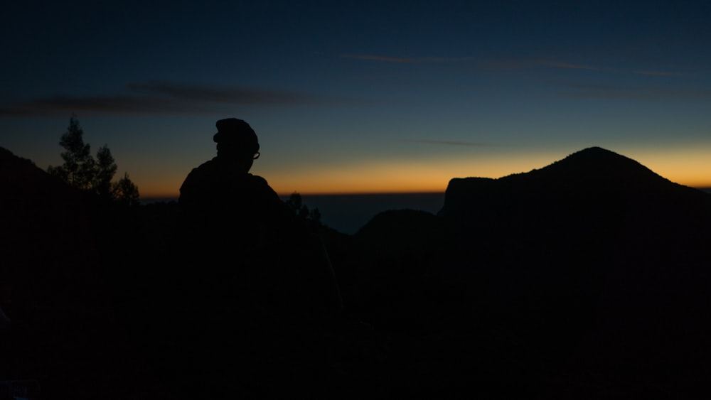 silhouette of person sitting during nighttime