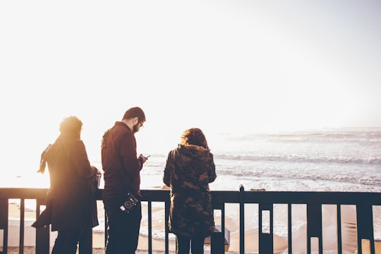 three people standing in front of beach in São Pedro de Moel Beach Portugal