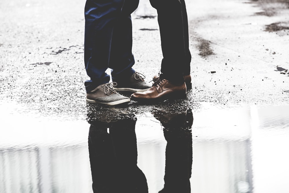 zwei Personen stehen auf der Straße neben einem Gewässer