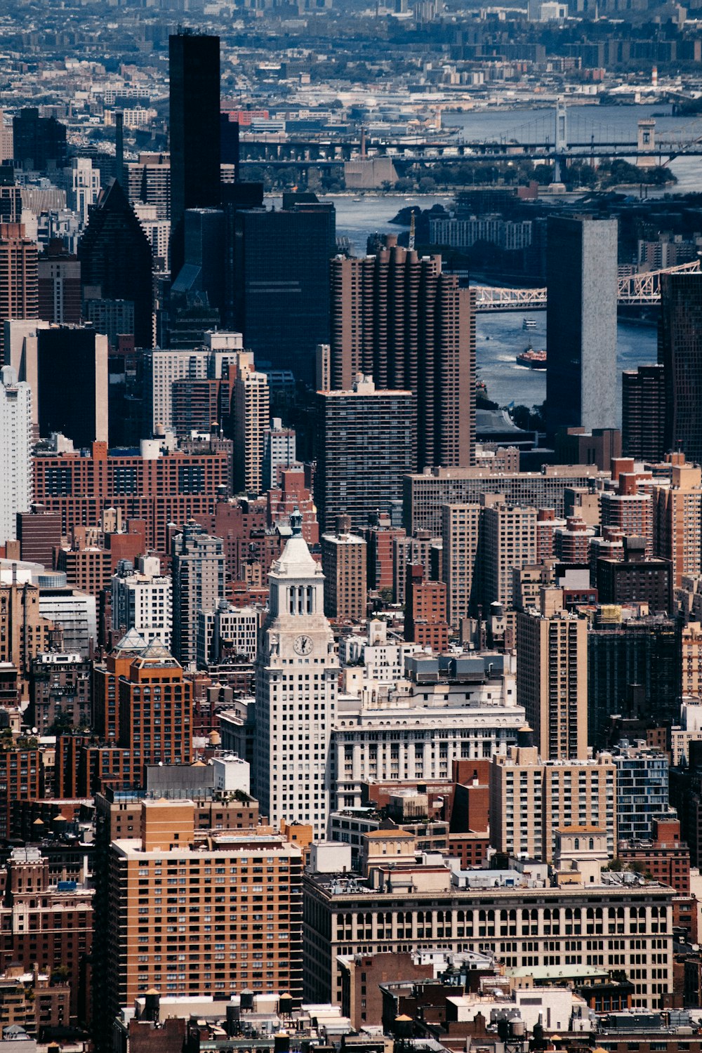 aerial photography of city buildings near river and bridge during daytime