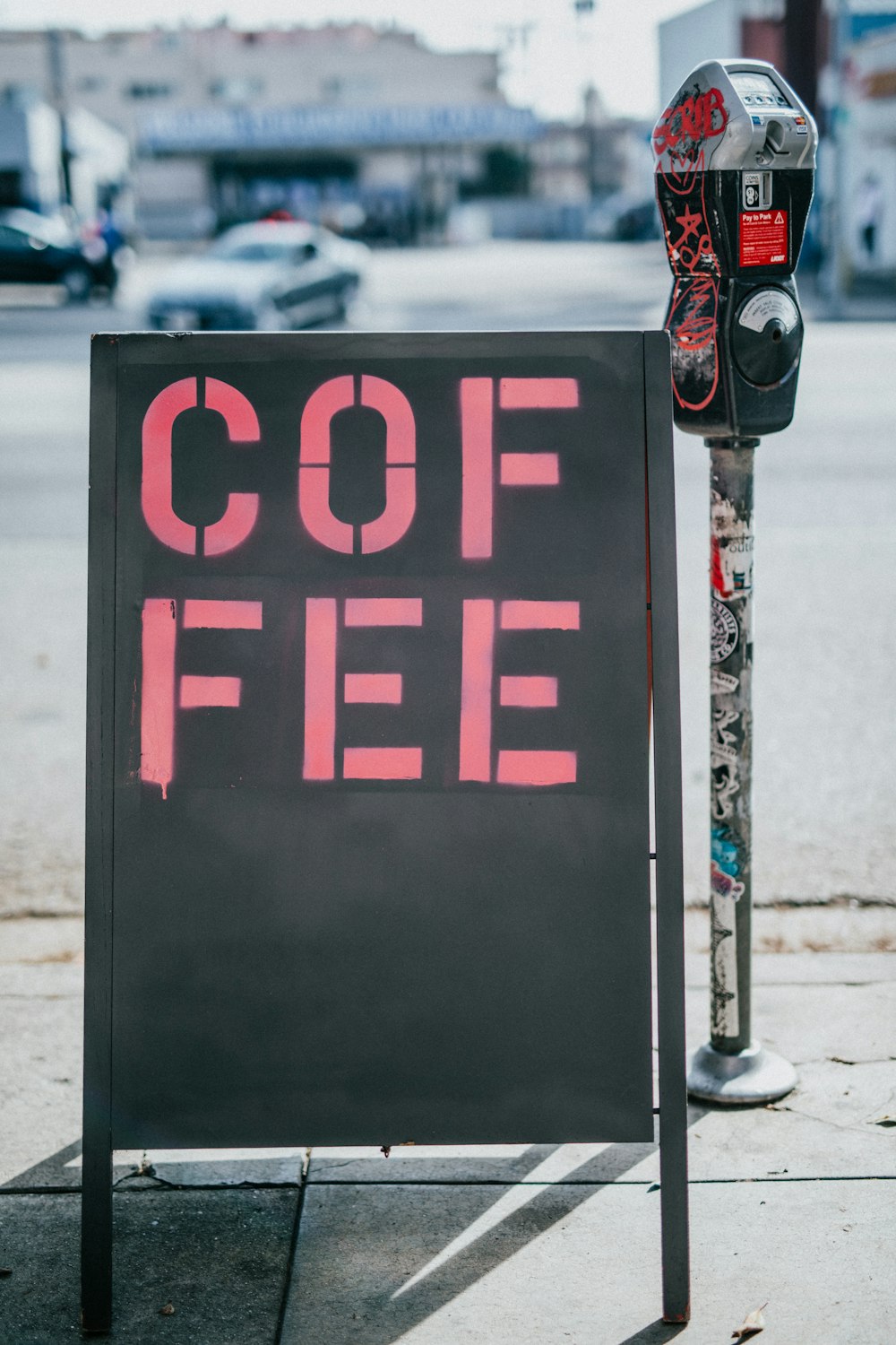 black freestanding signage with coffee print beside coin parking slot