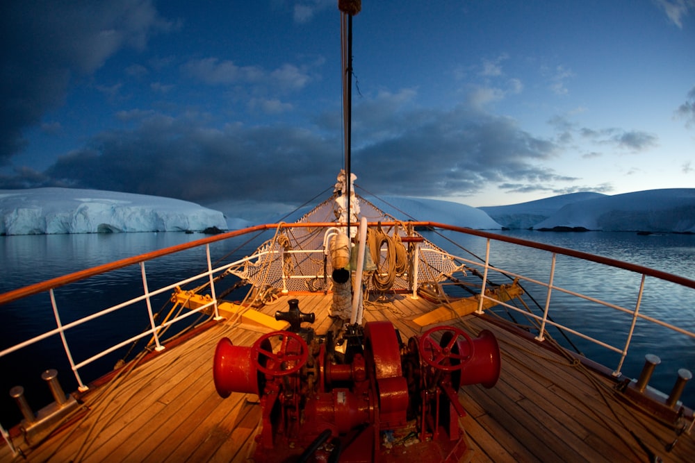 red and brown boat deck and iceberg at distance