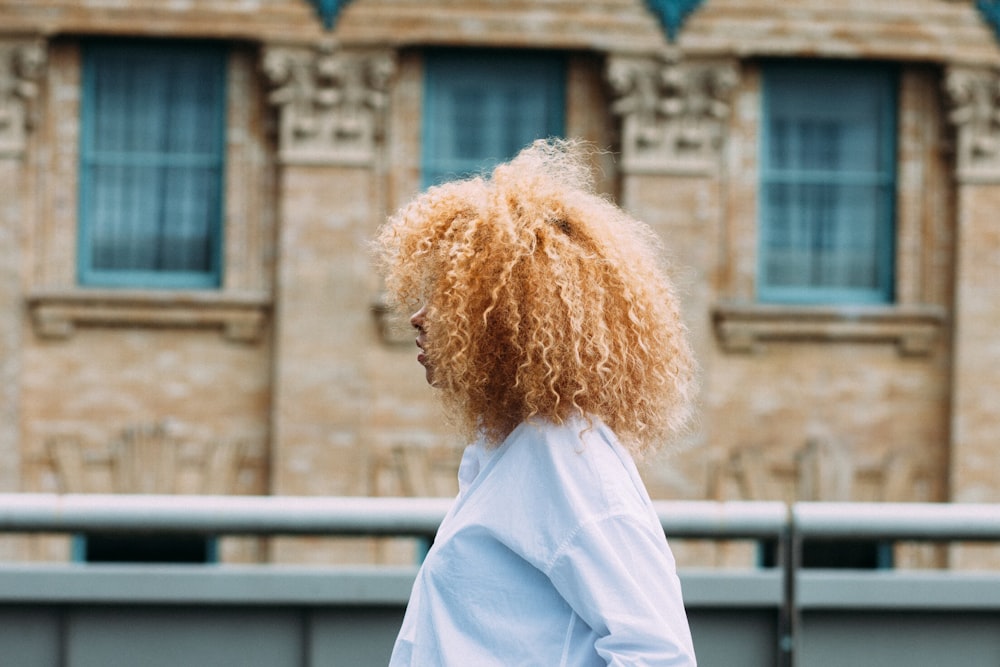 femme debout à côté d’une clôture en métal gris