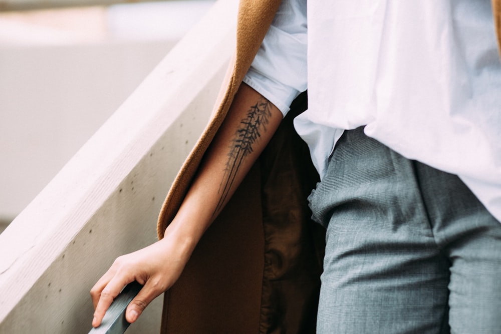 person holding gray handrail