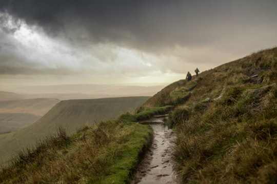 two person walking on green grass field mountain in Brecon Beacons National Park United Kingdom