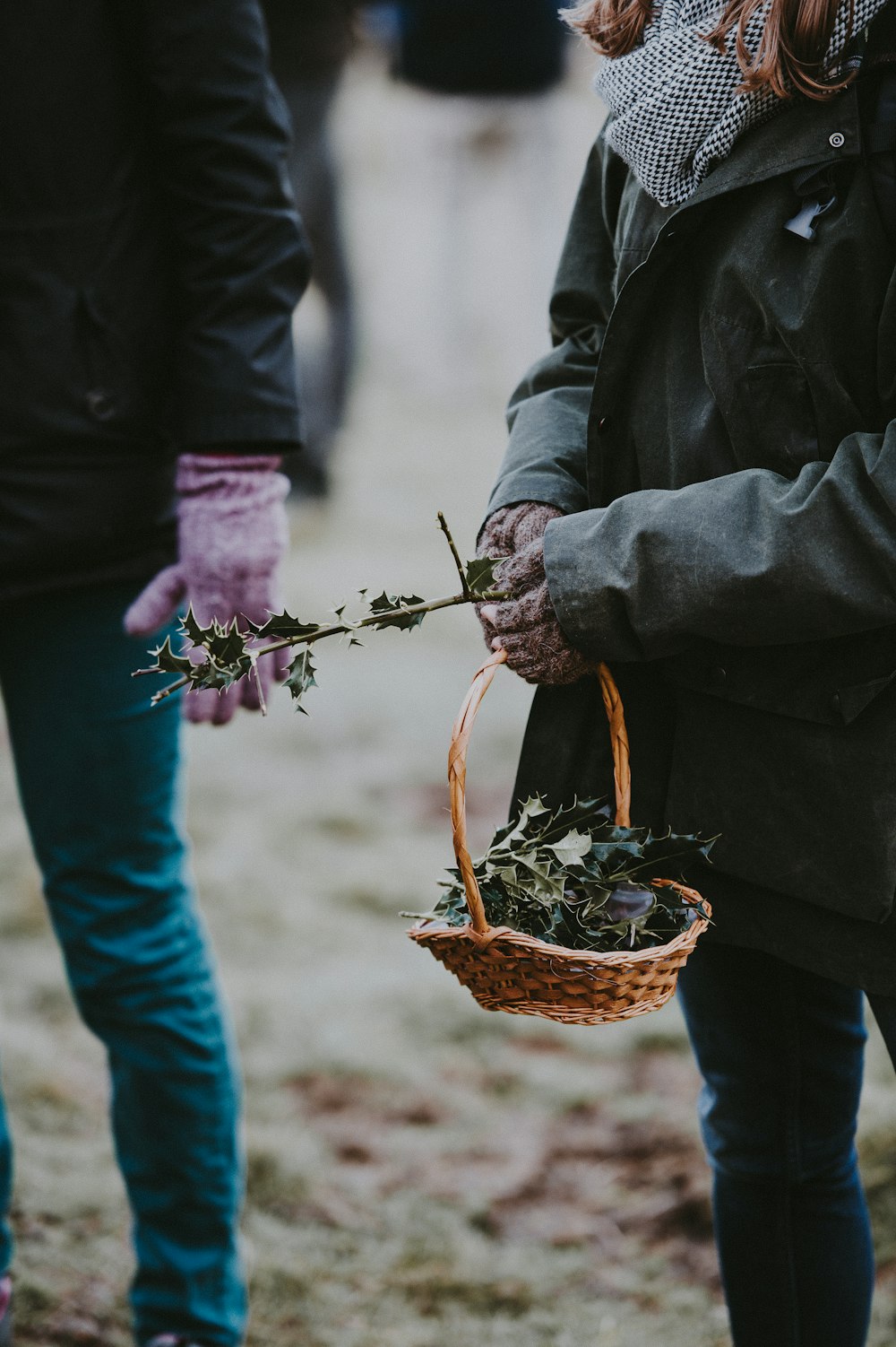 woman holding brown basket with leaves