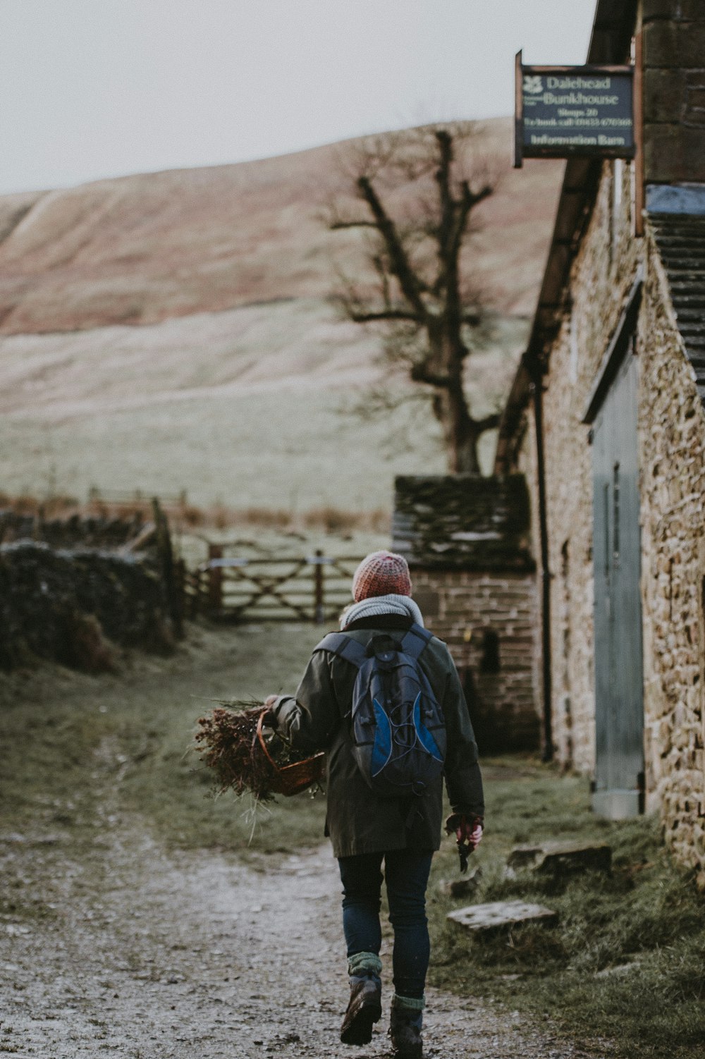 person holding basket walking across the gate