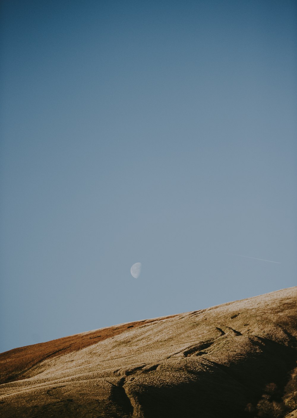 colline brune sous ciel bleu et blanc