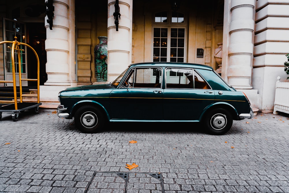 green sedan in front of white building