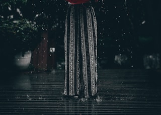 woman holding red umbrella standing near tree at daytime