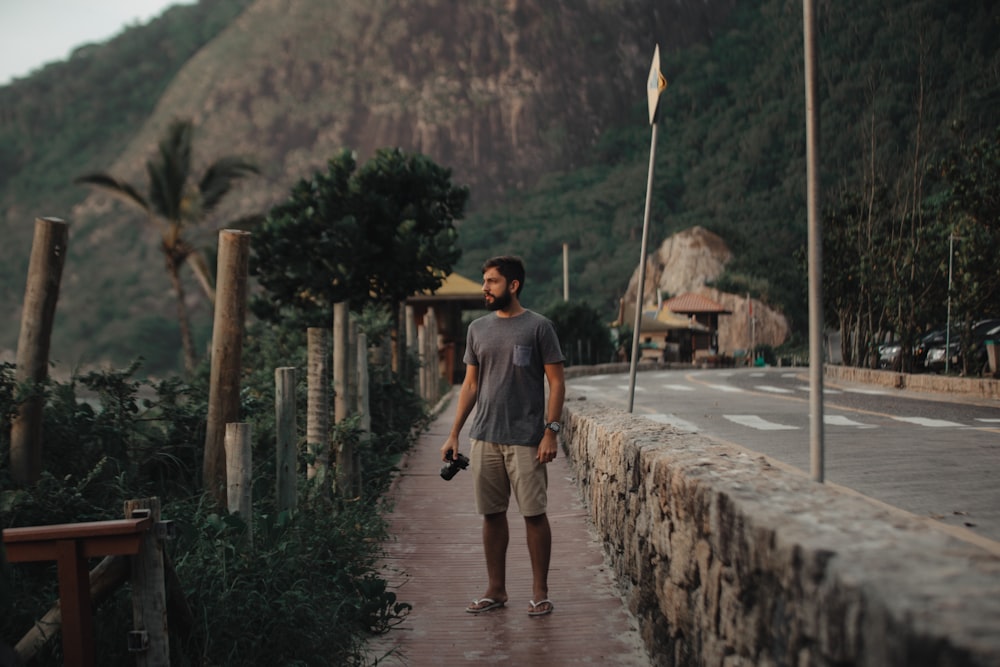 man standing beside road