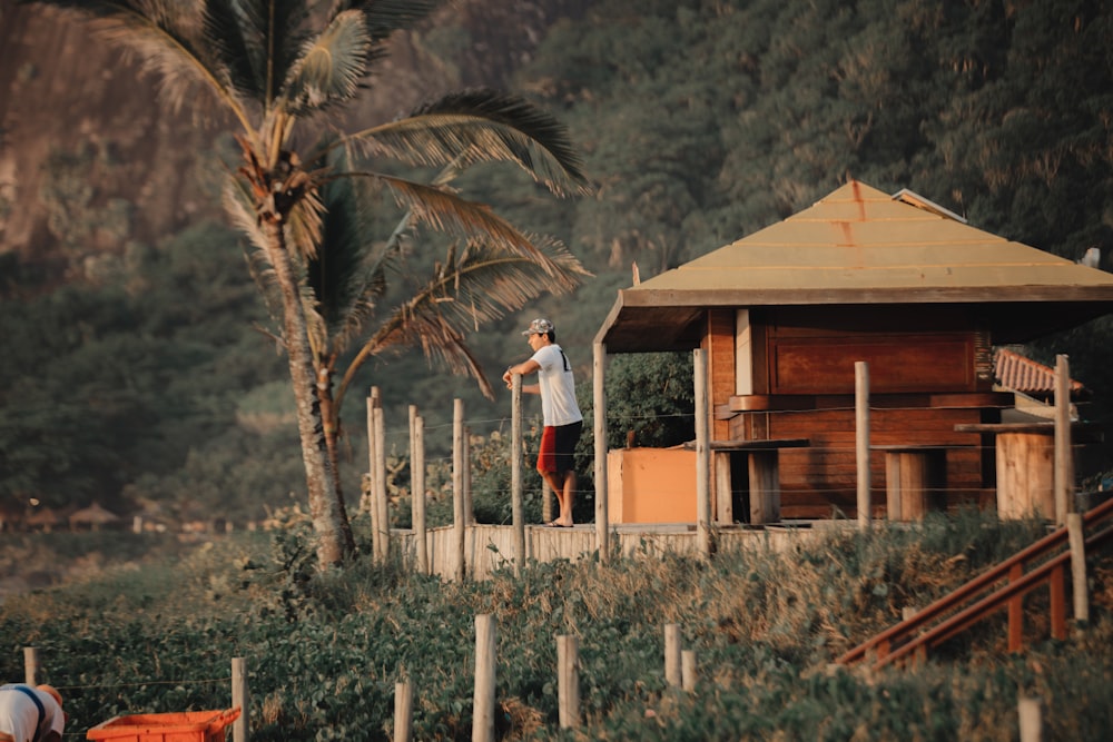 man standing on wooden hut