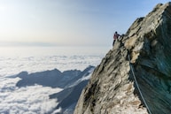 man climbing on gray mountain