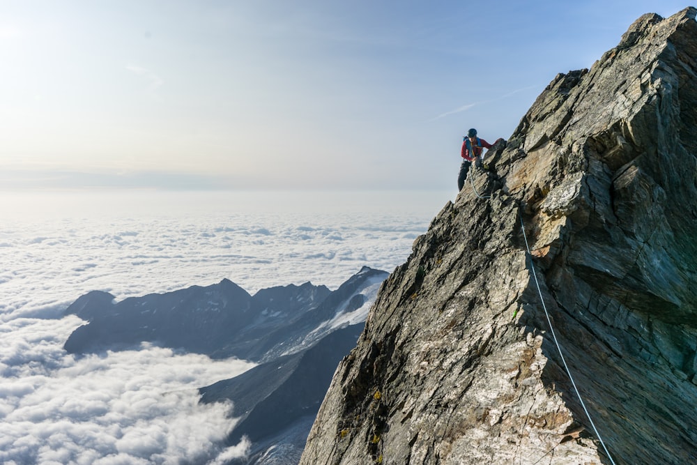 man climbing on gray mountain