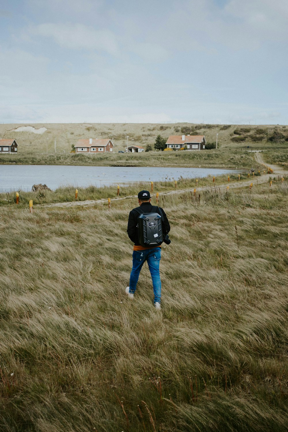 person wearing blue denim skinny jeans and black jacket walking on the grass