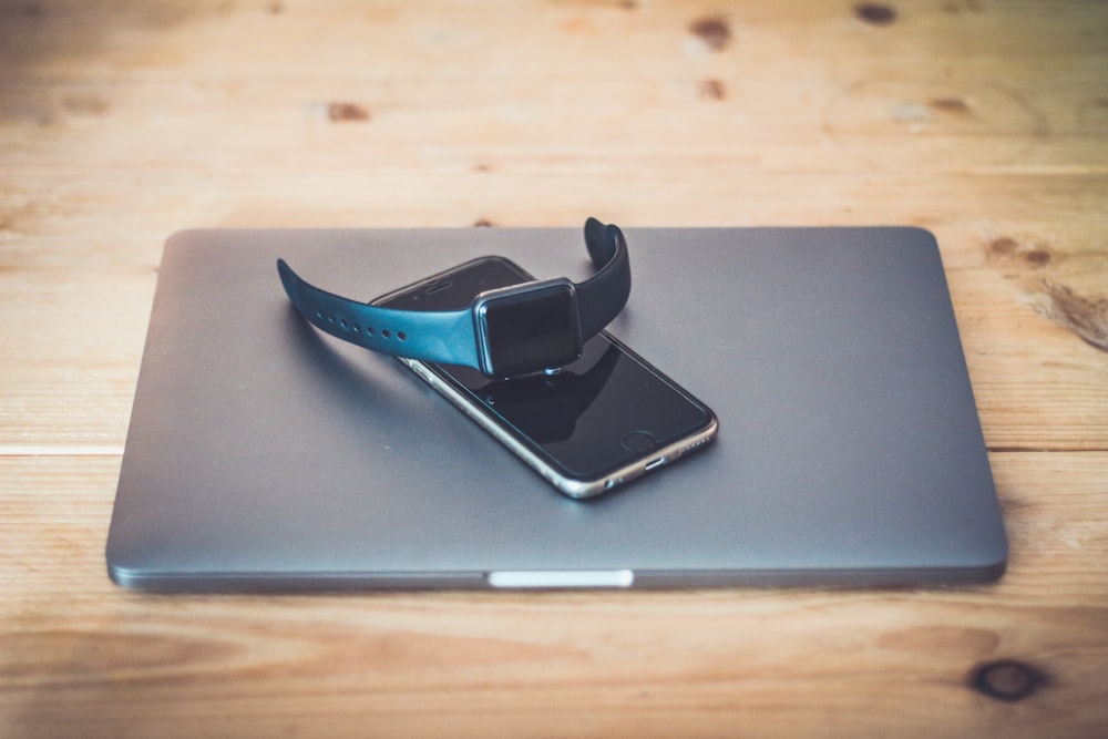 space gray Apple Watch on top of gray laptop computer