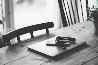 Elegant minimalist workspace with natural light and argan oil products on a wooden table.
