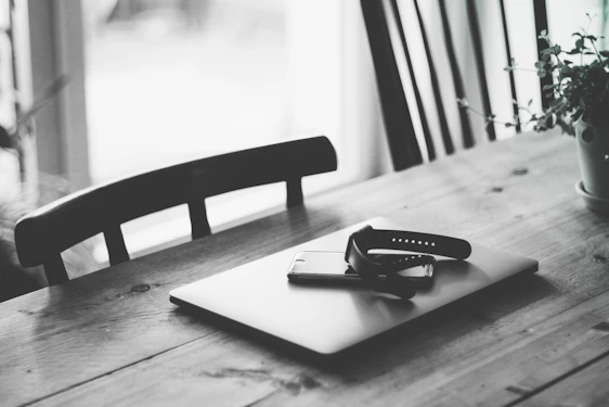 A cozy workspace with a sleek laptop, smartphone, and minimalist tech accessories on a wooden desk.
