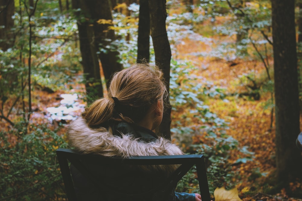 girl sitting on chair watching trees and plants