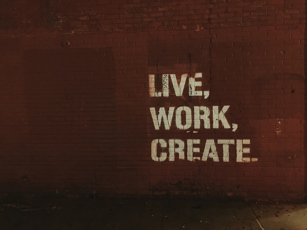 red brick wall with live, work, create. quote