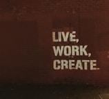 red brick wall with live, work, create. quote