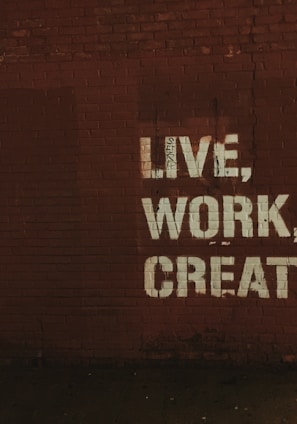 red brick wall with live, work, create. quote