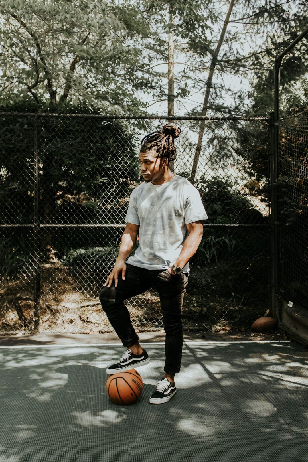 man stepping on brown basketball