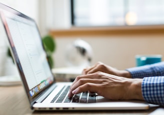 person typing on silver MacBook