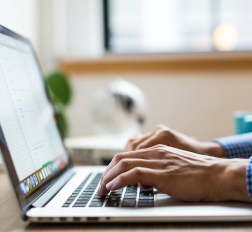 person typing on silver MacBook