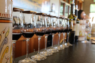 Elegant wine glasses filled with red and white wine on a polished bar counter.
