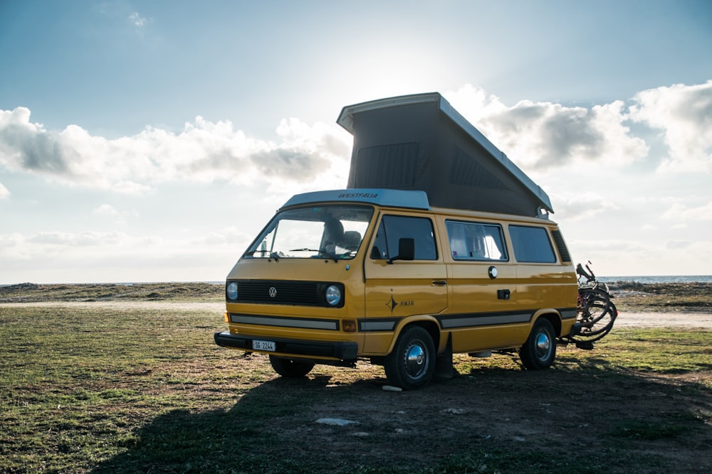 yellow Renault van parked on green grass at daytime