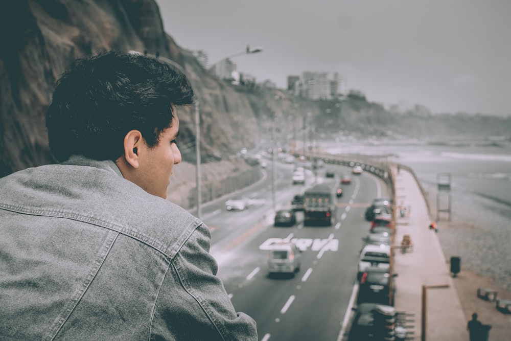 a man looking out over a highway filled with traffic