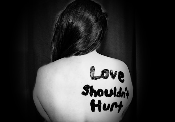 love shouldn't hurt-printed on back of woman