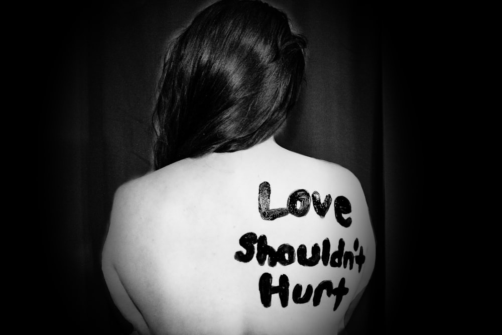 love shouldn't hurt-printed on back of woman