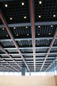 A spacious commercial area showcasing a grid ceiling system with recessed fixtures.